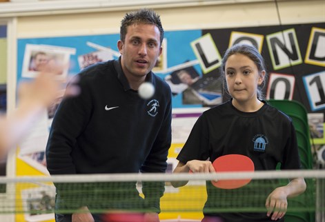 Coach and student playing table tennis